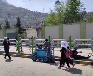 Children walking along a sidewalk in the city.