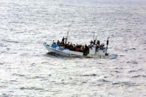People on a crowded small ship in open water.