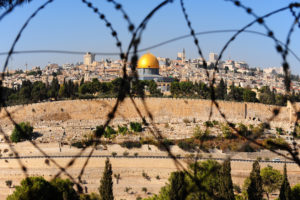 View from the Mount of Olives on the dome of the rock and ancient cemetery through the barbed wire, as a symbol of Palestine Israeli conflict. ©iStock.com/gkuna